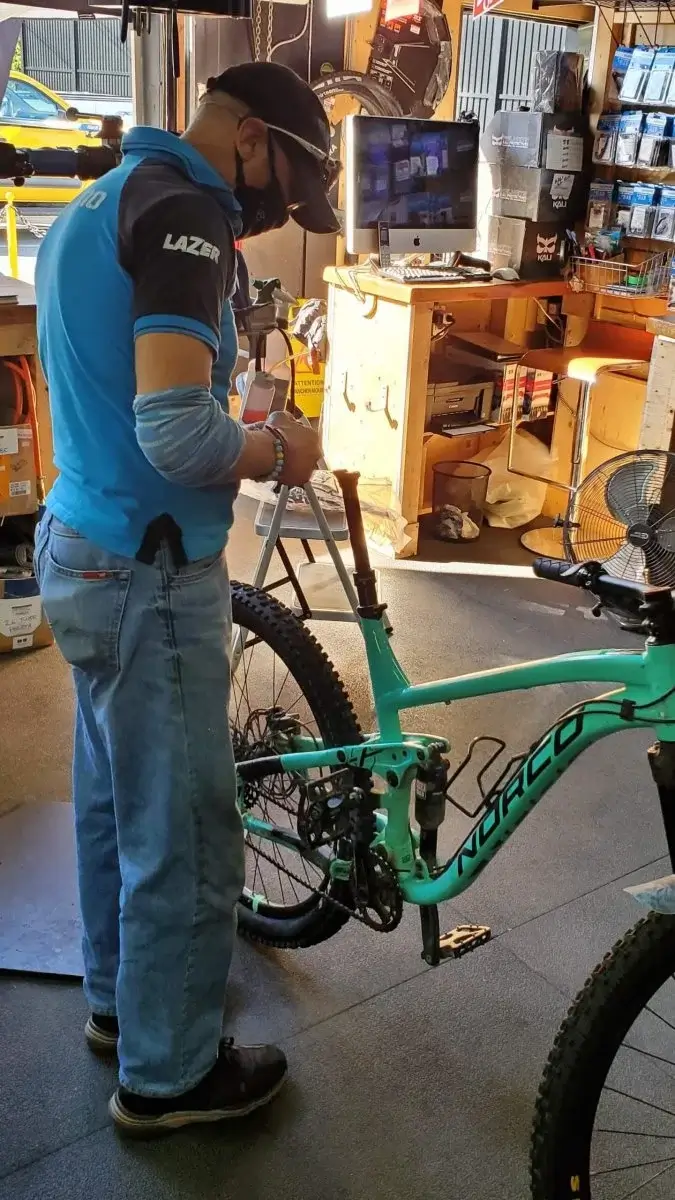 A picture of a man fixing a bike